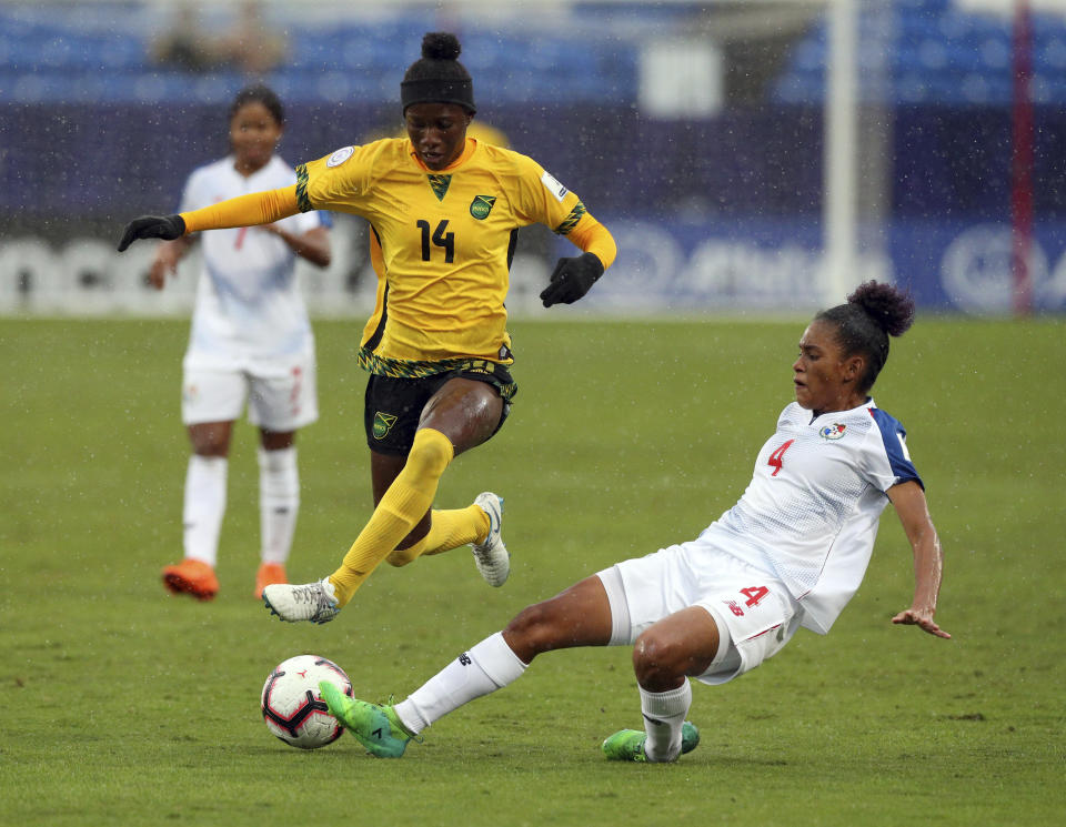 Jamaica midfielder Deneisha Blackwood (14) leaps as Panama midfielder Katherine Castillo (4) kicks the ball away during the first half of the third place match of the CONCACAF women's World Cup qualifying tournament, Wednesday, Oct. 17, 2018, in Frisco, Texas. (AP Photo/Richard W. Rodriguez)