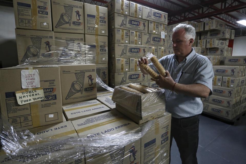 Jan Lelie, CFO of the Dafi foods factory, holds ice cream cones at the company's warehouse in Cali, Colombia, Saturday, May 22, 2021. The production of Dafi food factory has stopped for the past several days as the company struggles to get flour shipped to its factory in the western city of Cali, which is surrounded by roadblocks staged by anti-government protestors. (AP Photo/Andres Gonzalez)