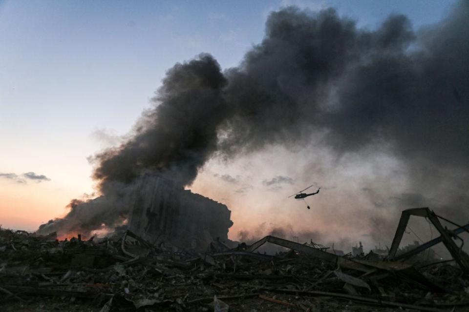 A helicopter puts out a fire at the scene of an explosion at the port of Lebanon's capital Beirut on August 4, 2020