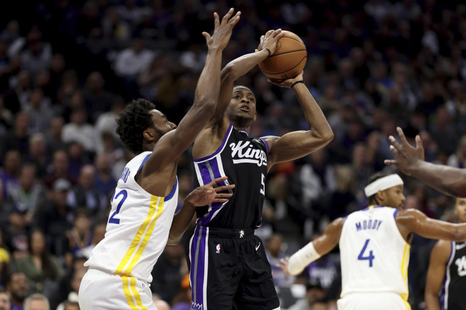 Sacramento Kings guard De'Aaron Fox (5) shoots against Golden State Warriors forward Andrew Wiggins (22) during the first half of an NBA basketball game in Sacramento, Calif, Friday, Oct. 27, 2023. (AP Photo/Jed Jacobsohn)