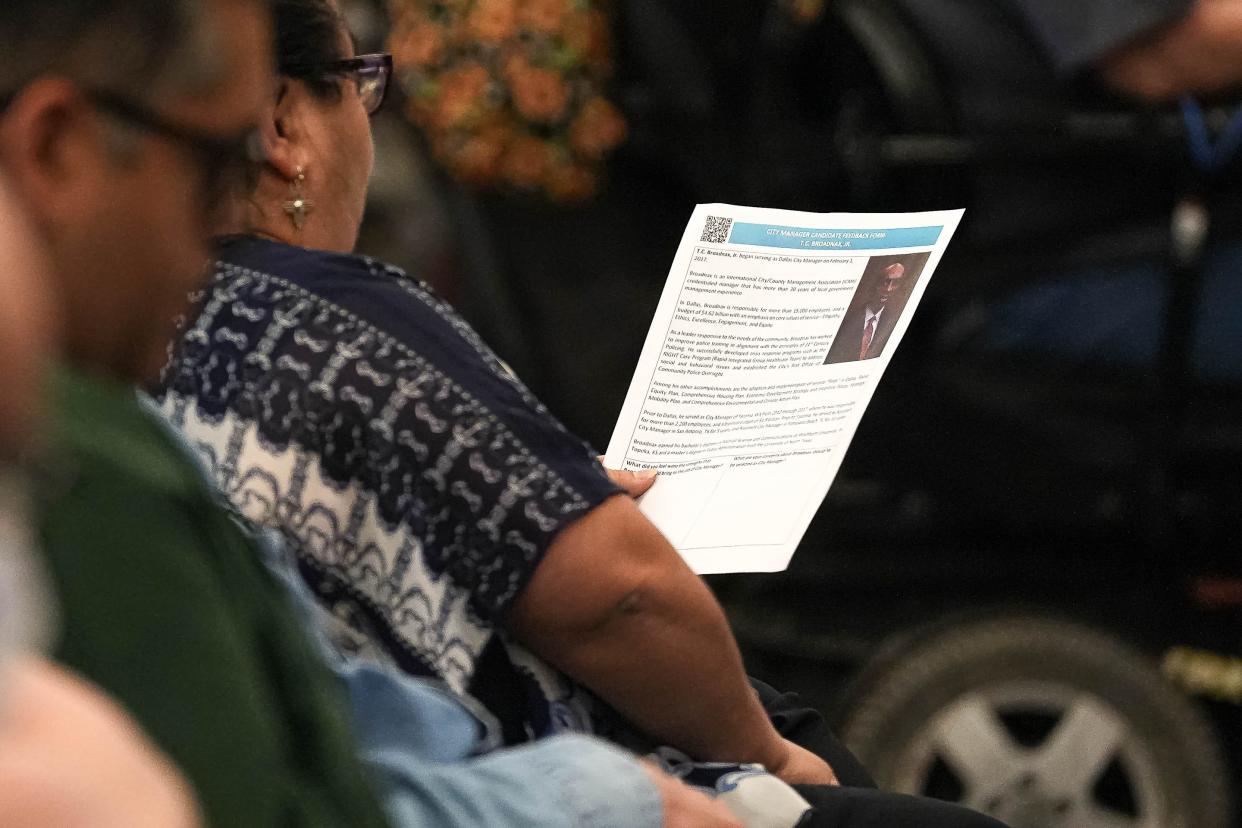 An attendee holds an information sheet on T.C. Broadnax during the March town hall session. As the city manager of Dallas, Broadnax's base salary was $50,000 less than what he'll receive in Austin.