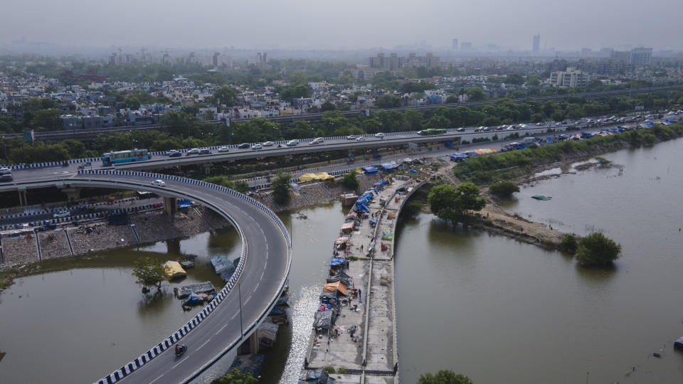 People who had to evacuate the flooded banks of Yamuna River take shelter on an under-construction overpass in New Delhi. 