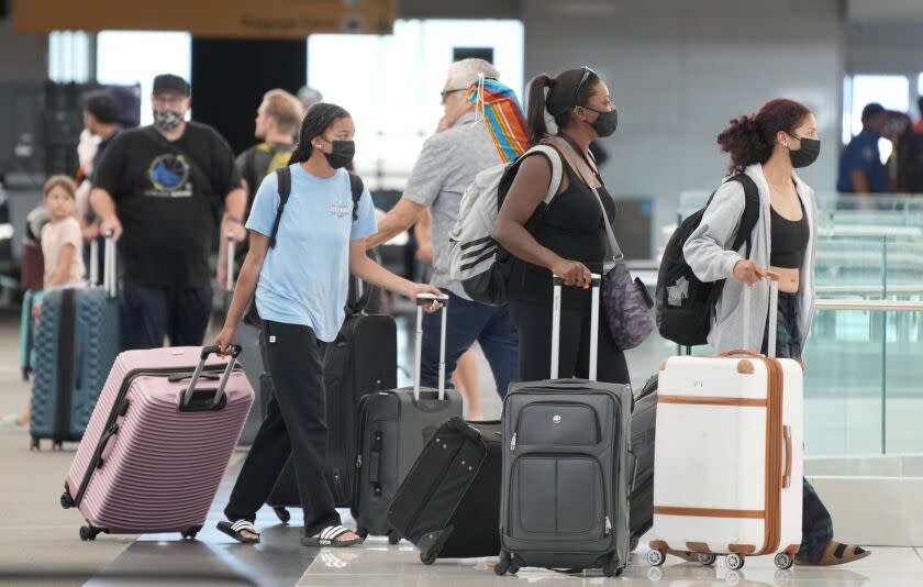 Travelers head to the check-in counter for Southwest Airlines at a terminal of Denver International Airport, Monday, July 4, 2022, in Denver. (AP Photo/David Zalubowski)