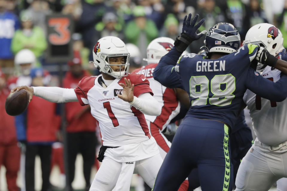 In this Sunday, Dec. 22, 2019, photo, Arizona Cardinals quarterback Kyler Murray passes as Seattle Seahawks defensive end Rasheem Green (98) applies pressure during the first half of an NFL football game in Seattle. Murray is short for an NFL quarterback at 5-foot-10, but it hasn't kept him from being very productive under first-year coach Kliff Kingsbury. Coaches and veteran players like receiver Larry Fitzgerald have raved about Murray's leadership, talent and toughness. (AP Photo/Elaine Thompson)