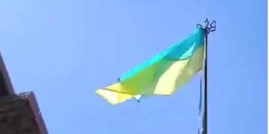 Ukrainian defenders raise a flag on the left bank of the Dnipro River in Kherson region
