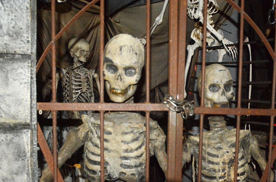 File photo of skeletons shake a loose gate at guests at The Dark Manor Haunted House.