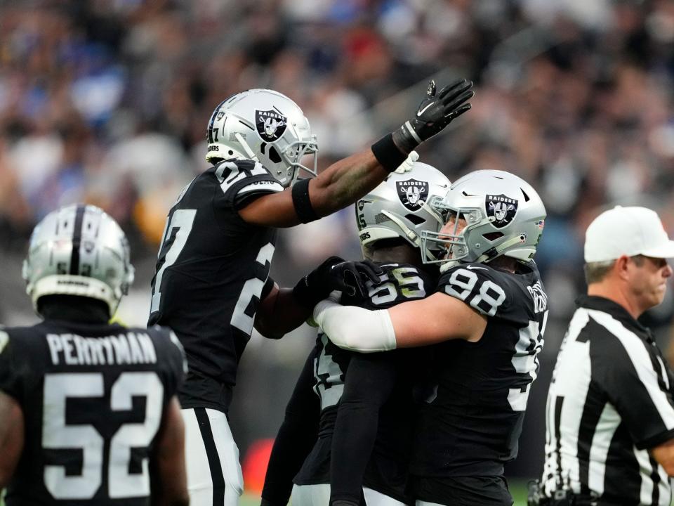 The Las Vegas Raiders defense celebrates after sacking Justin Herbert.