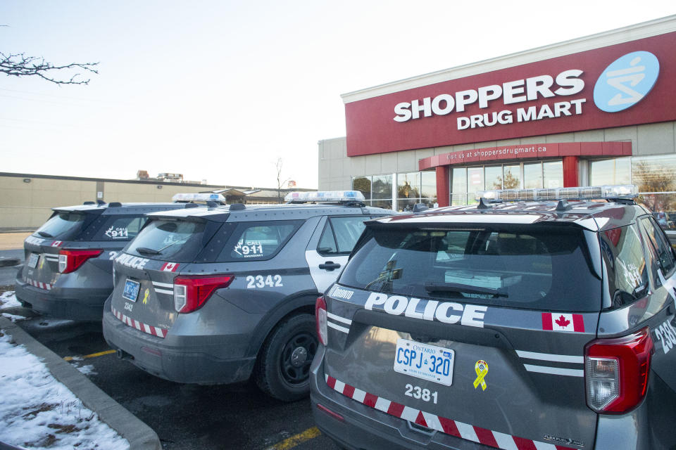 Police cruisers are deployed outside a Shoppers Drug Mart in Etobicoke, Ont. as Ontario Premier Doug Ford receives his COVID-19 booster shot, on Tuesday, December 21, 2021. THE CANADIAN PRESS/Chris Young