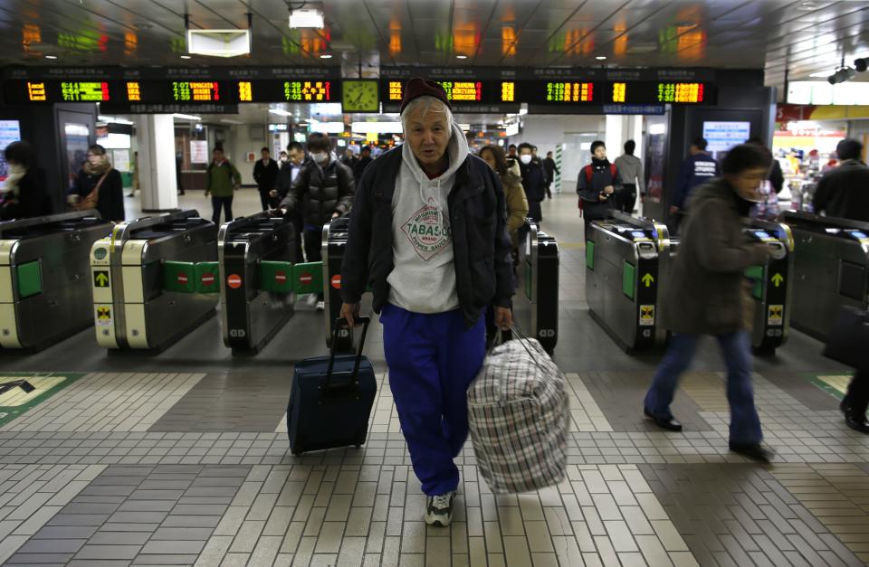 Shizuya Nishiyama, a 57-year-old homeless man from Hokkaido, poses for a photo in front of an automatic ticket barrier at Sendai Station in Sendai, northern Japan