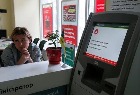 An employee sits next to a payment terminal out of order at a branch of Ukraine's state-owned bank Oschadbank after Ukrainian institutions were hit by a wave of cyber attacks earlier in the day, in Kiev, Ukraine, June 27, 2017. REUTERS/Valentyn Ogirenko