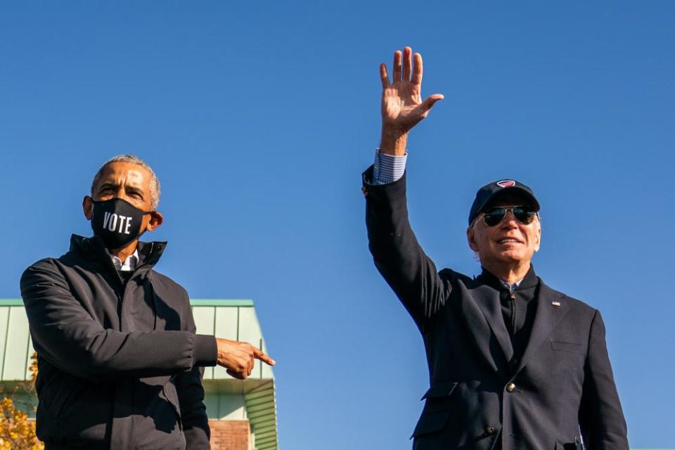 Barack Obama and Joe Biden on stage during a mobilization event at Northwestern high school in Flint, Michigan, on 31 October.