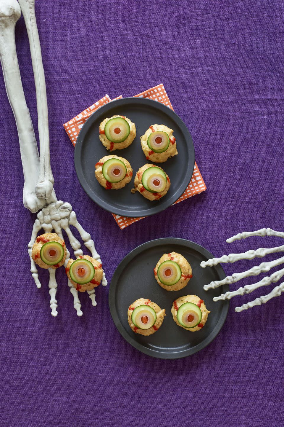 <p>Top these cheese pastry puffs with slices of cucumber, olives, and squiggles of spicy Sriracha for a Halloween treat you won't be able to take your eyes off.</p><p><strong><a rel="nofollow noopener" href="https://www.womansday.com/food-recipes/recipes/a60165/bitesize-eyeballs-recipe/" target="_blank" data-ylk="slk:Get the recipe;elm:context_link;itc:0;sec:content-canvas" class="link ">Get the recipe</a>.</strong></p>