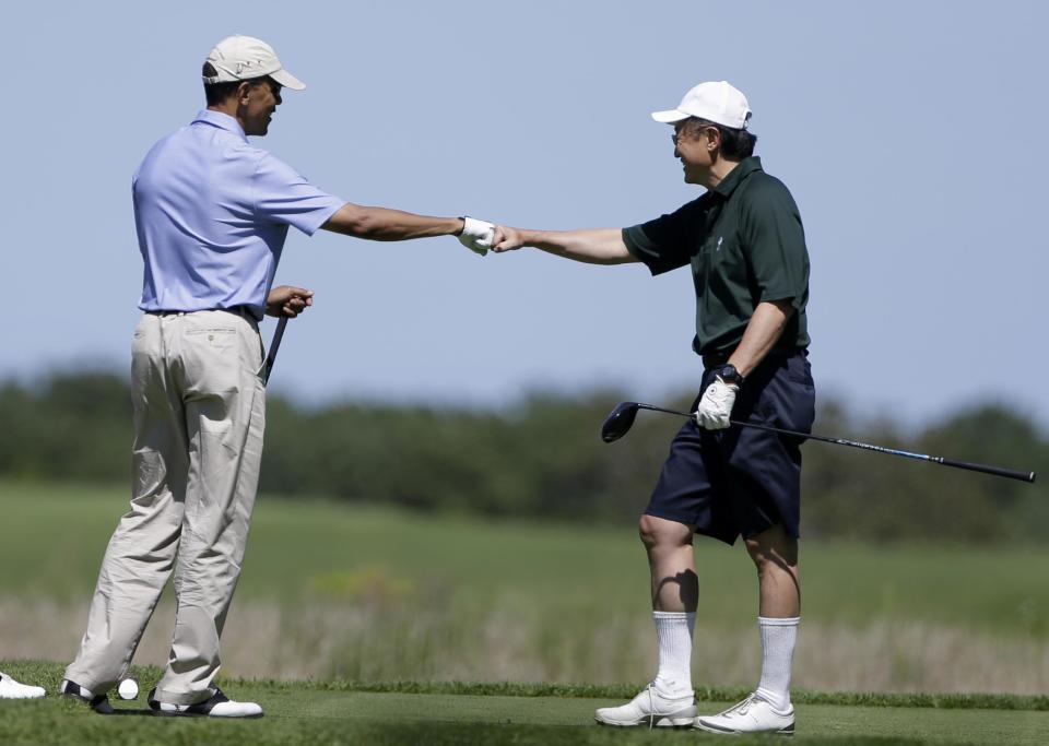 President Barack Obama fist bumps World Bank President Jim Kim after Kim teed off during their golf outing at Vineyard Golf Club in Edgartown, Mass., on the island of Martha's Vineyard Wednesday, Aug. 14, 2013. (AP Photo/Steven Senne)