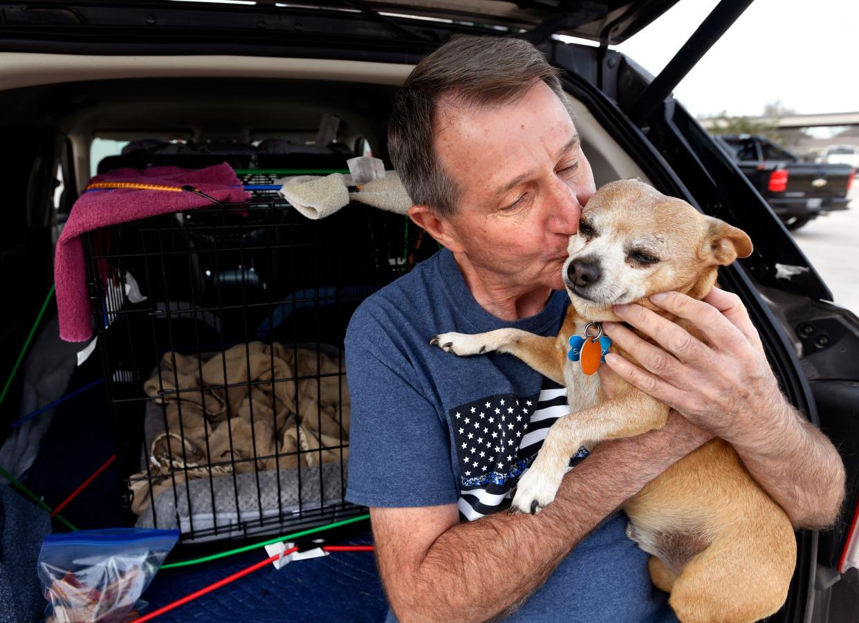 Ritchie Rud returns a smooch to a pet belonging to a Meals on Wheels client that he was bringing for treatment to Big Country Veterinary Clinic on Dec. 16.