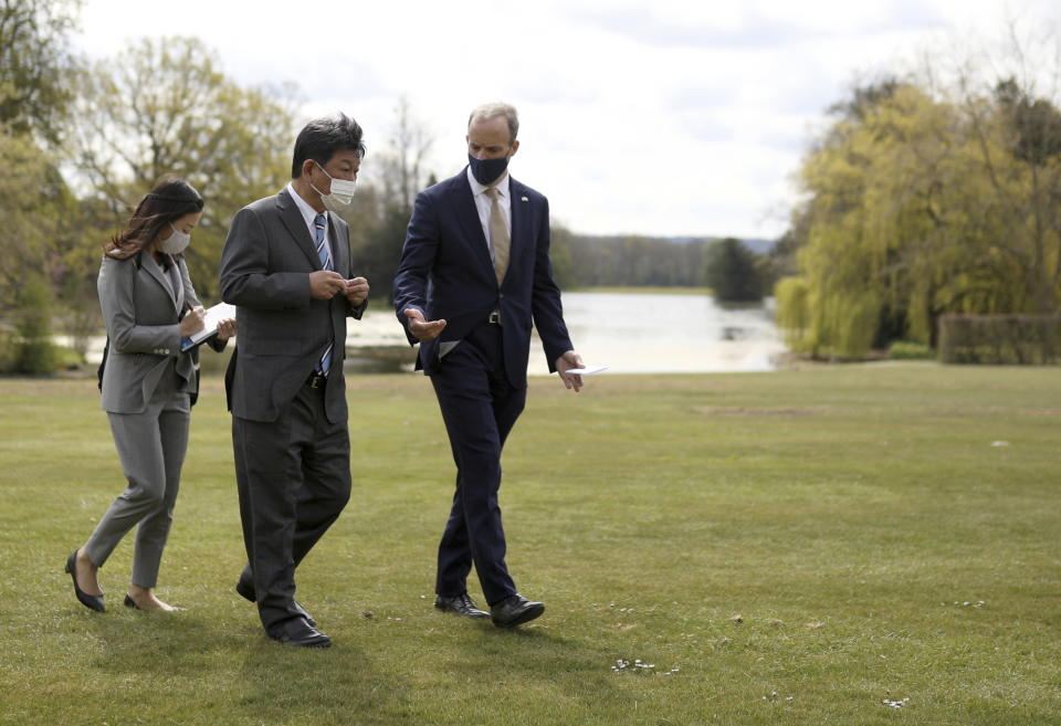 Britain's Foreign Secretary Dominic Raab, right, walks with Japan's Foreign Minister Toshimitsu Motegi, centre, during their talks in Kent, southern England, Monday May 3, 2021. (Tom Nicholson/Pool via AP)