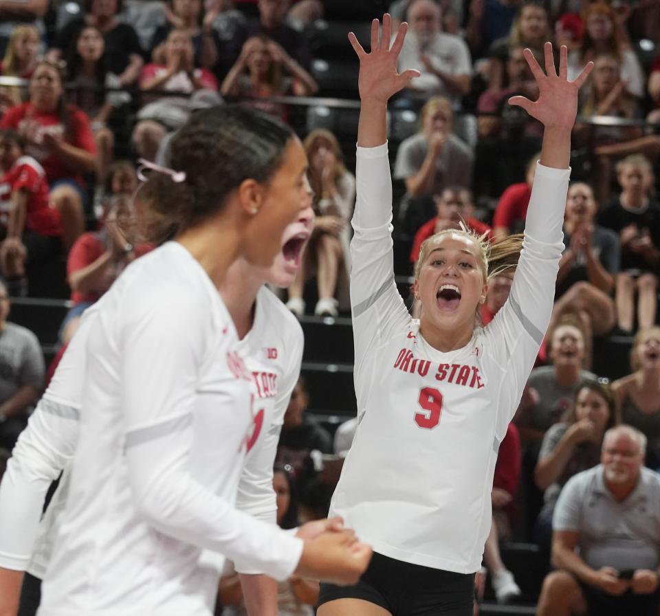 Aug 19, 2023; Columbus, Ohio, United States;  Mia Tuman (right) celebrates with. teammates inside the Covelli Center during an exhibition game against Pitt. Tuman is a freshman setter for Ohio State women's volleyball. Her father, Jerame Tuman, played for Michigan football, and Mia grew up a huge Michigan fan. Her mother, Molly Tuman,  was a Division 1 volleyball player at Kentucky.