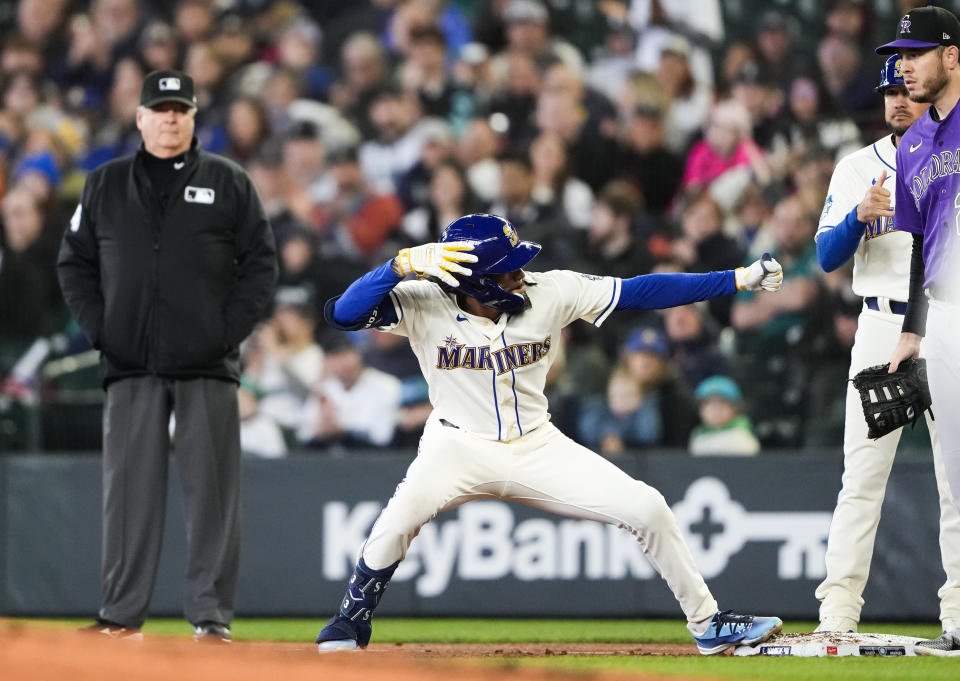Seattle Mariners' J.P. Crawford, center, reacts after hitting a single against the Colorado Rockies during the third inning of a baseball game Sunday, April 16, 2023, in Seattle. (AP Photo/Lindsey Wasson)
