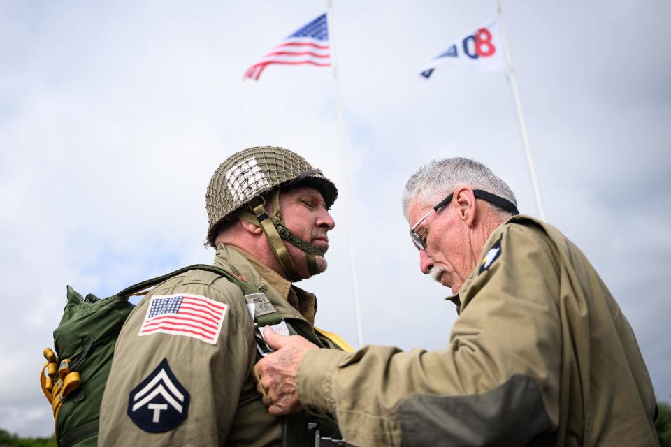 Parachutists wearing replica WWII-era paratrooper attire prior to their jump from a Lockheed C-130 Hercules aircraft chartered and navigated by US crew, on June 5, 2024, at the Cherbourg airport, in Normandy, France.