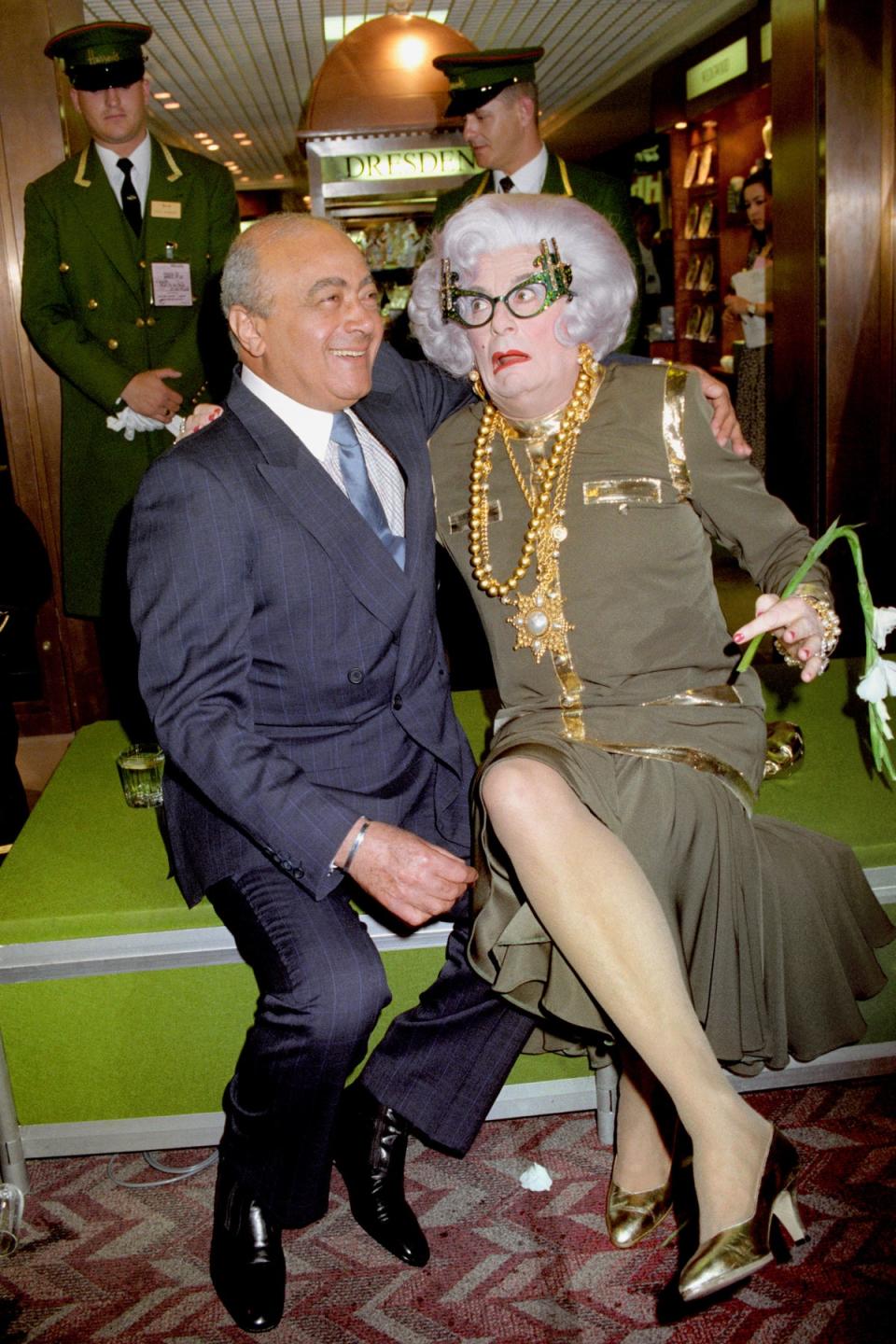 Mohammed Al-Fayed, owner of Harrods, with Dame Edna at the opening of a Harrods Room of Luxury at Heathrow Airport (PA)