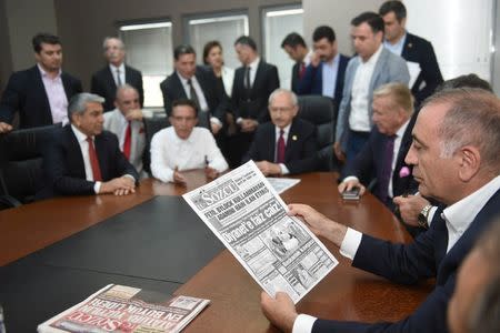 Gursel Tekin, a lawmaker from the main opposition Republican People's Party (CHP) holds a print copy of Sozcu daily newspaper as they visit the publication's headquarters in Istanbul, Turkey, May 19, 2017. REUTERS/Ziya Koseoglu