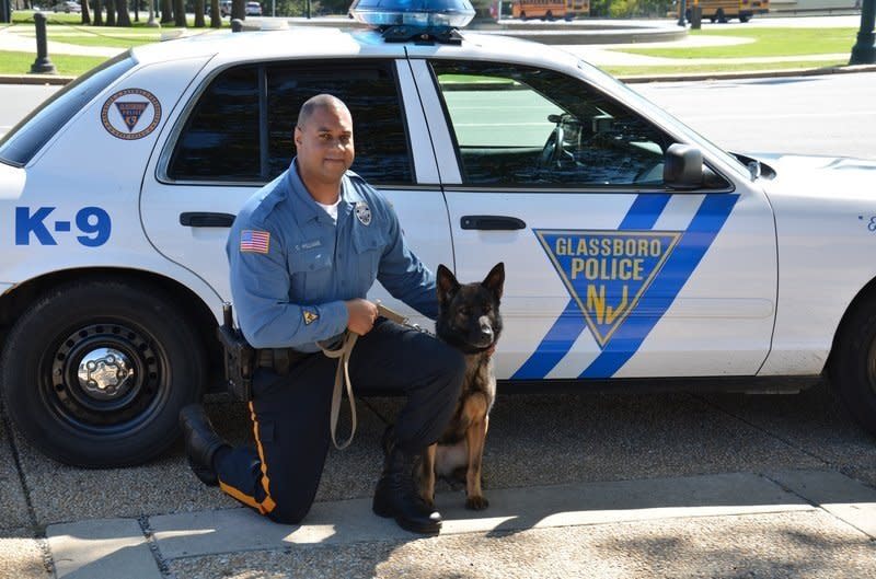 This undated photo provided by Glassboro NJ Police Department shows Patrolman Charles Williams and his K-9 partner Anka.  Authorities say the police K-9 dog has died after it was spooked by fireworks in southern New Jersey and was hit by car after escaping from its kennel. The 6-year-old German Shepherd was killed Saturday, July 5, 2014.  The dog's partner, Glassboro Patrolman Charles Williams, found the dog missing when he returned home Saturday night. An off-duty officer found her in the street about a half mile away after police from Glassboro and surrounding towns began searching for the dog. (AP Photo/Glassboro NJ Police Department)