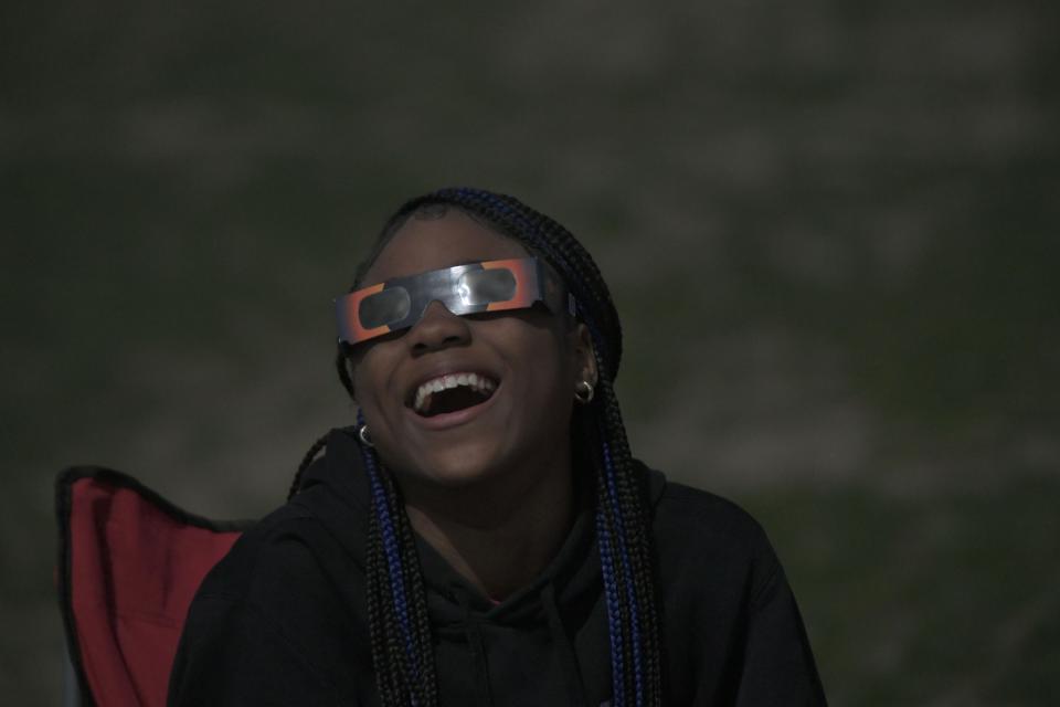 Trinity Lewis, 12, of Columbus, enjoys the return of the sun after totality Monday at the Ohio State Reformatory.