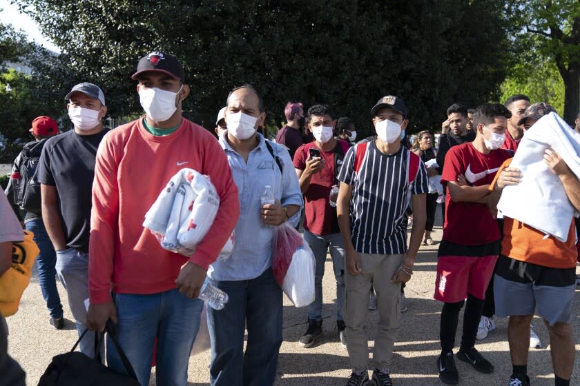 Migrantes llevan cobertores de la Cruz Roja después de llegar a Union Station, cerca del Capitolio federal desde Texas, el 27 de abril de 2022, en Washington. (AP Foto/Jose Luis Magana, Archivo)