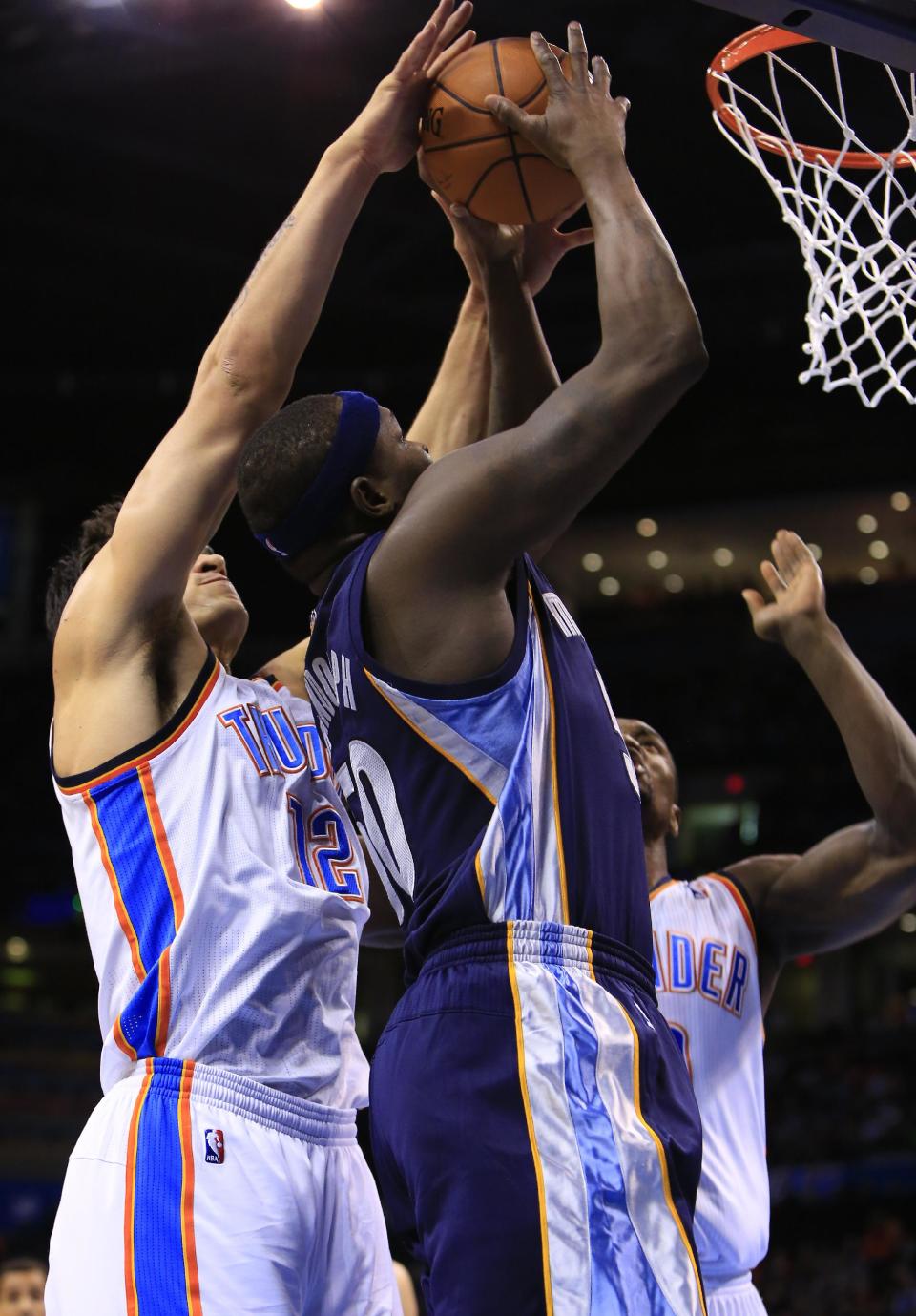 Memphis Grizzlies forward Zach Randolph, center, goes to the basket as Oklahoma City Thunder center Steven Adams (12) and Serge Ibaka, right, defend during the first quarter of an NBA basketball game on Monday, Feb. 3, 2014, in Oklahoma City. (AP Photo/Alonzo Adams)