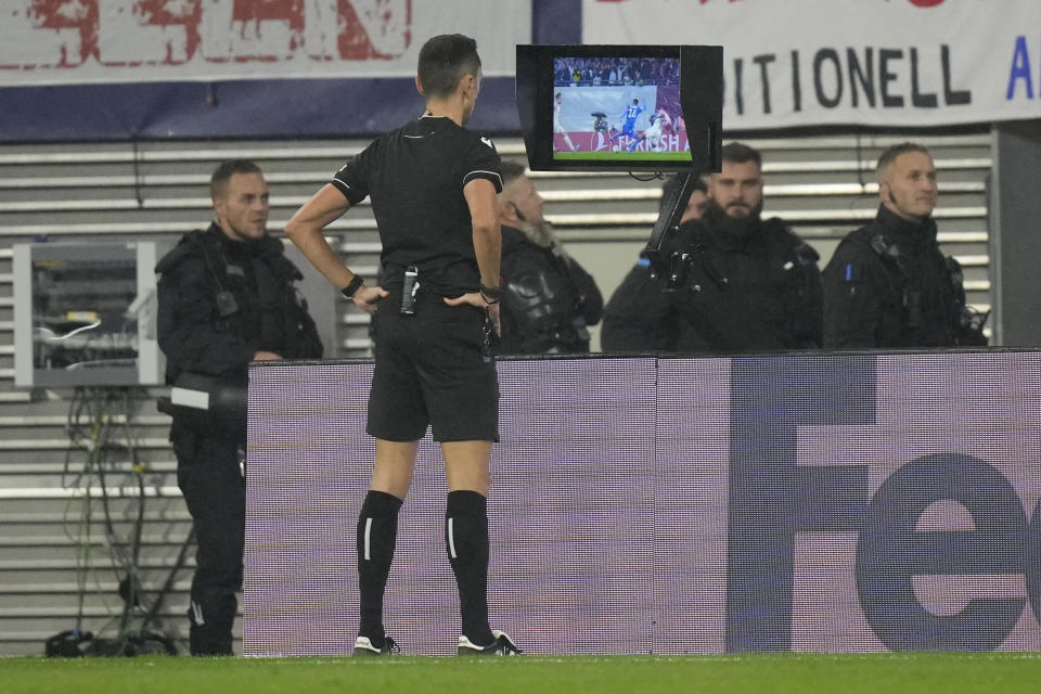 Referee Jose Maria Sanchez looks at the VAR screen during the group G Champions League soccer match between RB Leipzig and Red Star Belgrade at the Red Bull arena stadium in Leipzig, Germany, Wednesday, Oct. 25, 2023. (AP Photo/Matthias Schrader)