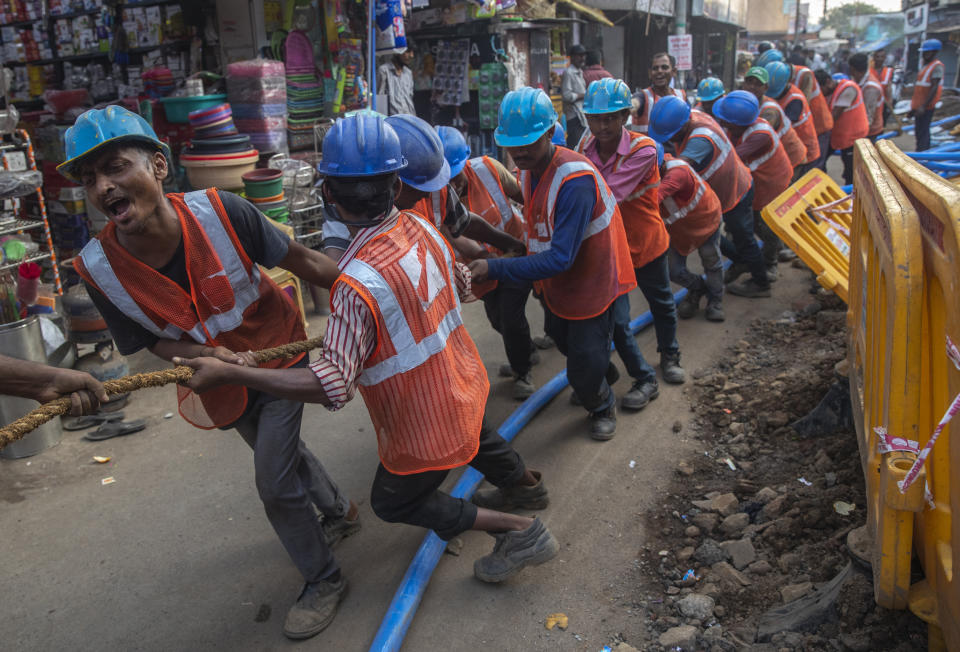 FILE - Workers prepare work to lay an underground electricity cable in Mumbai, India Wednesday, Nov. 24, 2021. India’s economy grew by 8.4% in the July-September quarter from the same period a year earlier, the government announced Tuesday, signaling hopes of a growing economic recovery after it suffered historic contractions sparked by the COVID-19 pandemic. (AP Photo/Rafiq Maqbool, File)