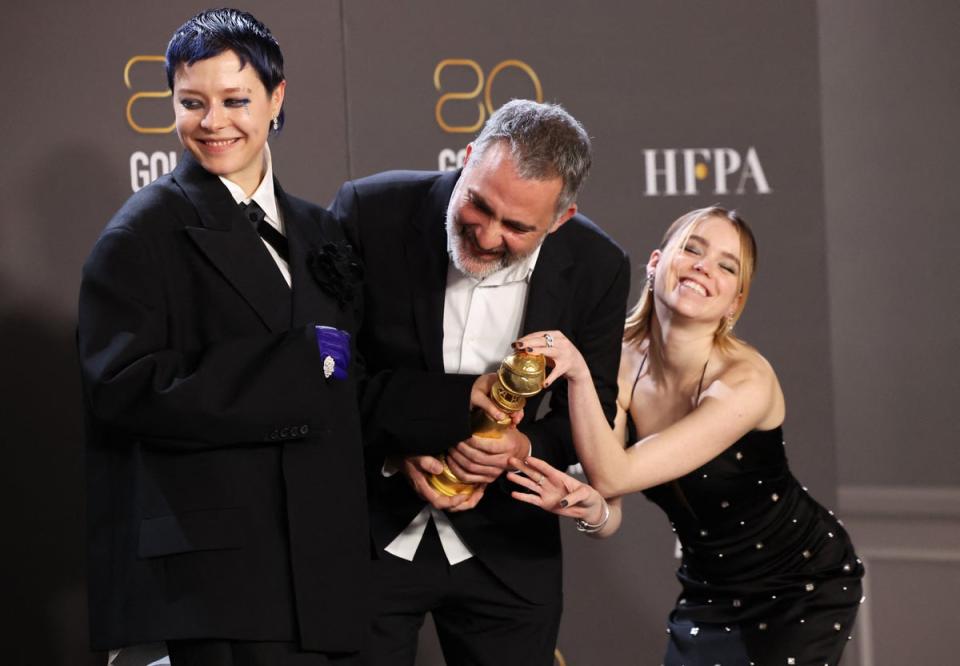 Emma D’Arcy, Miguel Sapochnik, and Milly Alcock pose with the award for Best Television Series in Drama for House of the Dragon (REUTERS)