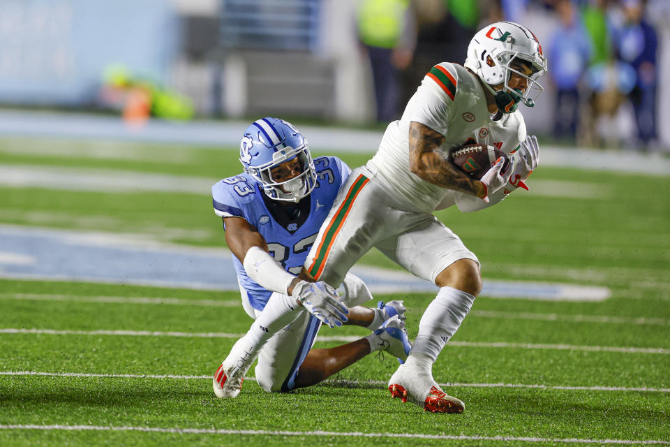 Oct 14, 2023; Chapel Hill, North Carolina, USA; Miami Hurricanes wide receiver Xavier Restrepo (7) escapes from North Carolina Tar Heels linebacker Cedric Gray (33) after a catch in the second half at Kenan Memorial Stadium. Mandatory Credit: Nell Redmond-USA TODAY Sports