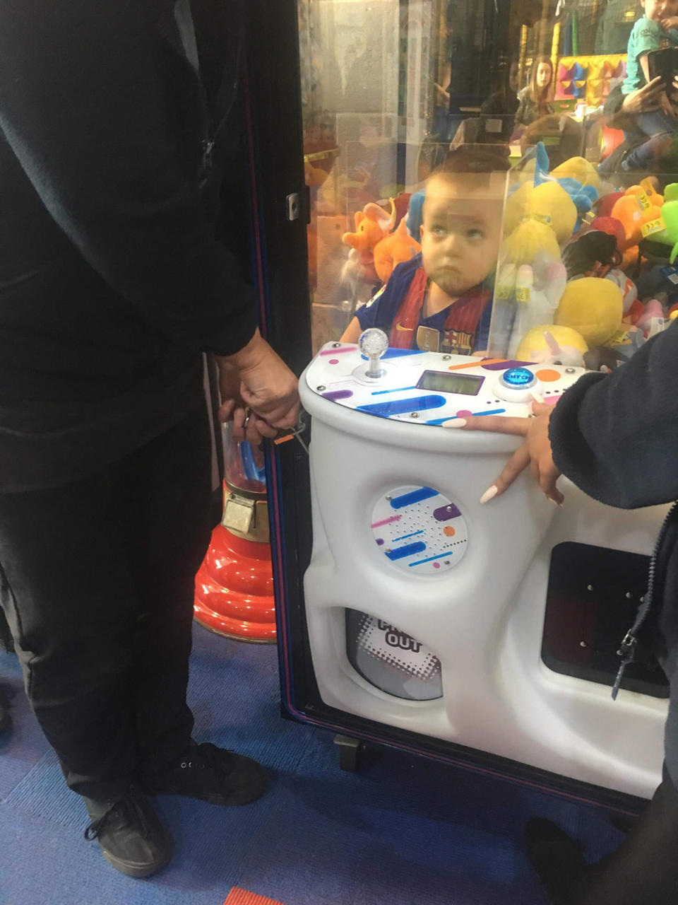 Noah Draper pictured trapped inside a toy machine after climbing in to get himself a teddy.