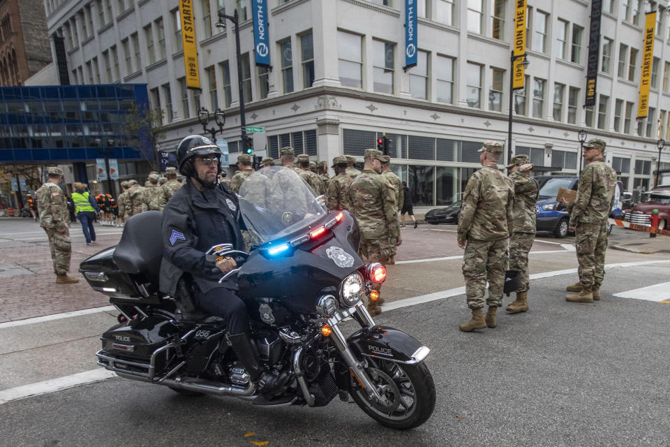 A police officer on a motorcycle drives along the route of a Veterans’ Day parade in Milwaukee on Saturday, Nov. 5, 2022. Incidents at parades and other public events across the country have caused officials to tighten security to try to keep people safe. Last November, the driver of an SUV sped through a Christmas parade in nearby Waukesha, Wisconsin, killing six and injuring dozens of other people. (AP Photo/Kenny Yoo)