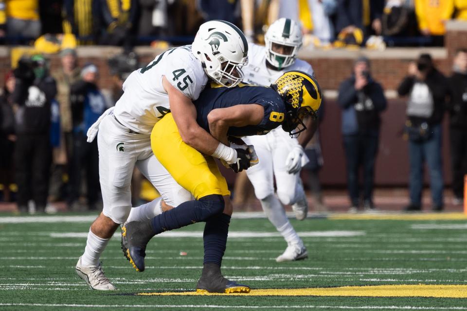 Michigan State linebacker Noah Harvey tackles Michigan wide receiver Ronnie Bell after he completed a pass during the game at Michigan Stadium on Saturday, Nov. 16, 2019.