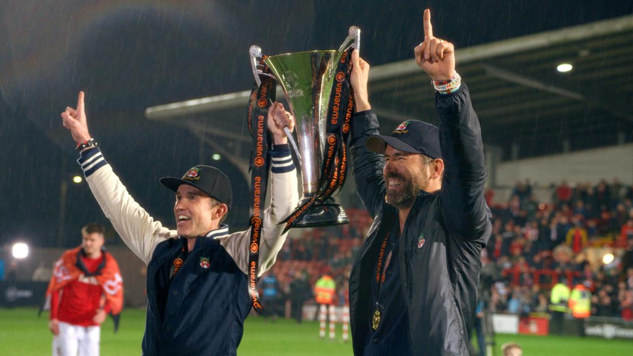 Wrexham AFC owners Rob McElhenney and Ryan Reynolds celebrate the Welsh soccer club's promotion out of the National League.