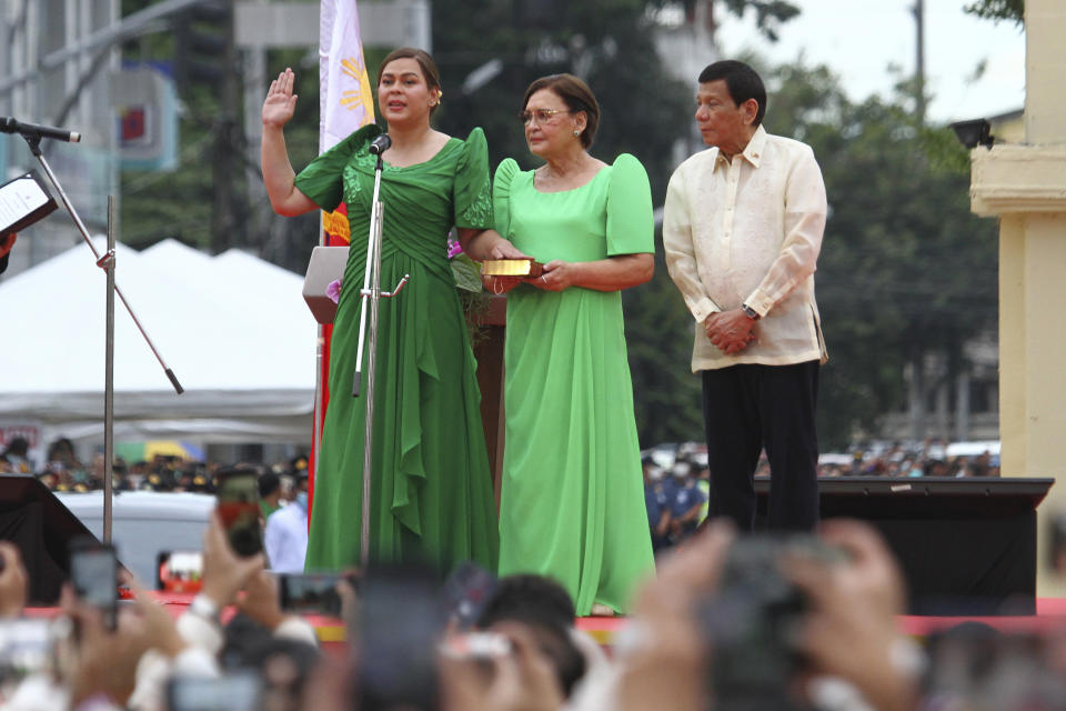 Sara Duterte, left, takes her oath as vice president beside her parents Elizabeth Zimmerman, center, and outgoing President Rodrigo Duterte during rites in her hometown in Davao city, southern Philippines on Sunday June 19, 2022. Duterte clinched a landslide electoral victory despite her father's human rights record that saw thousands of drug suspects gunned down. (AP Photo/Manman Dejeto)