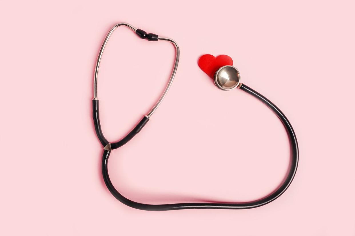 medical stethoscope with red hearts flat lay on pink background nurses day concept