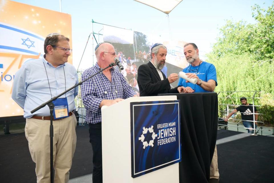 Miami rabbis (left to right) Fred Klein, Mario Rojzman, Yossi Harlig and Eliot Pearlson light a candle in memory of the 98 people who perished in the Surfside tragedy.