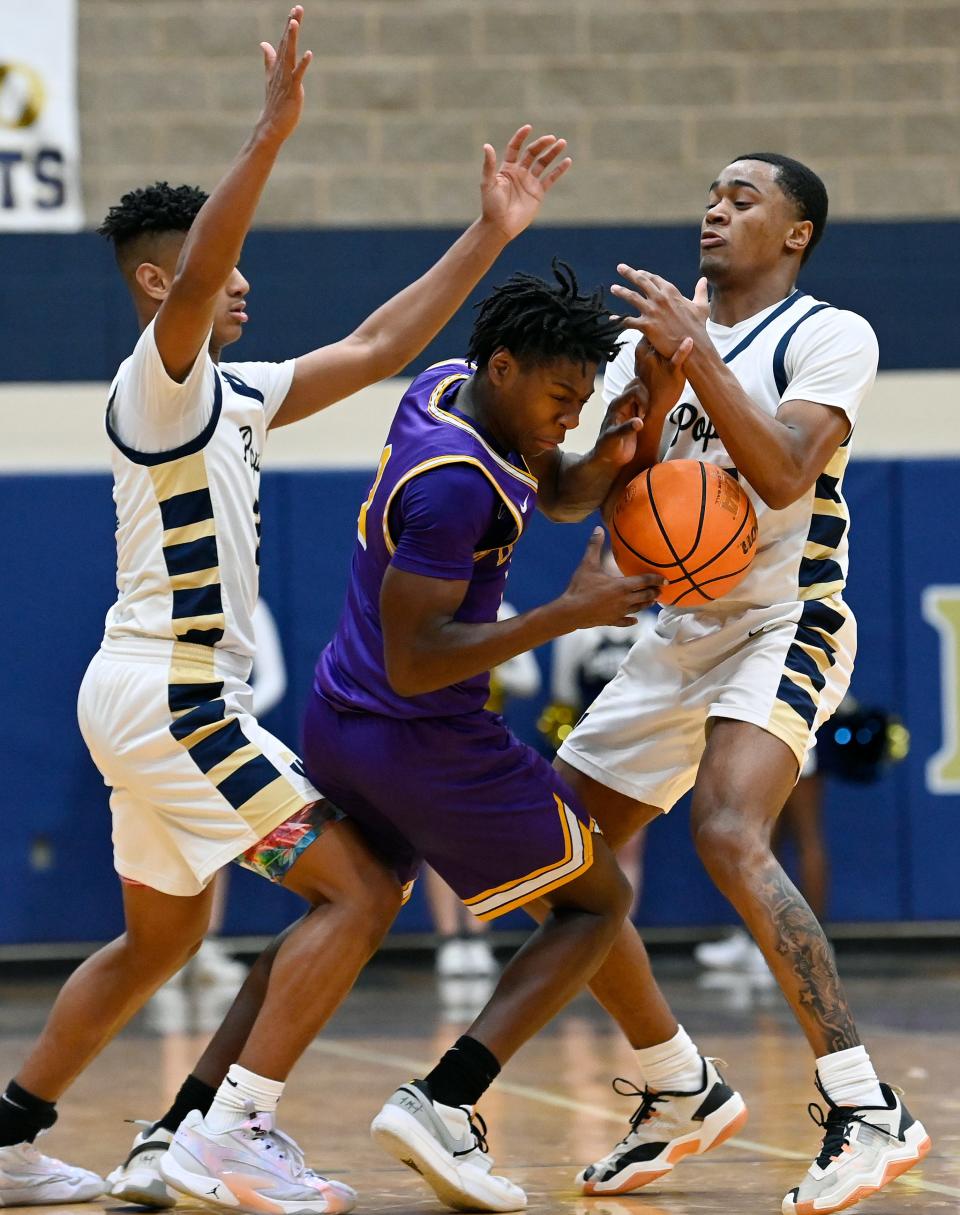 Lipscomb Academy guard Cam Blivens, center, keeps control of the ball as JPII’s Trey Pearson, left, and Fred Bailey, right, double team Blivens during an high school basketball game Monday, Jan. 24, 2024, in Hendersonville, Tenn.