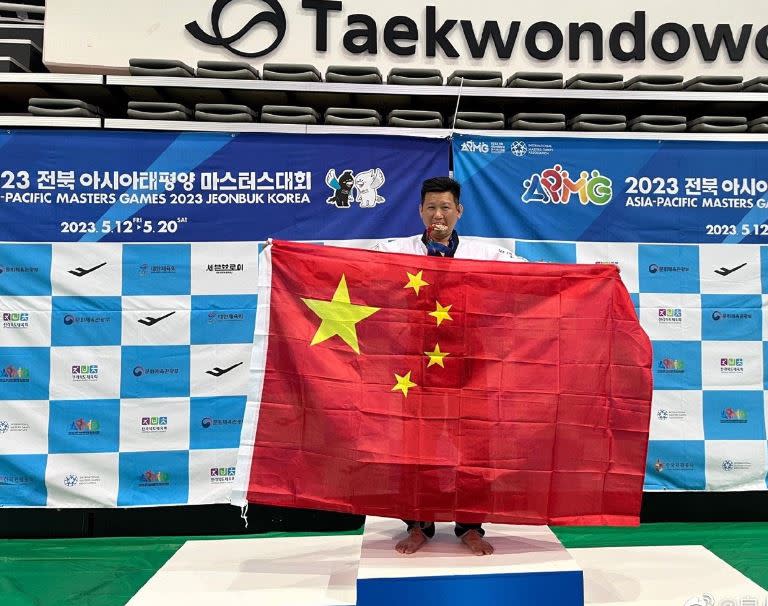 台灣跆拳道選手李東憲在亞太壯年運動會奪銅，頒獎台高舉中國五星旗畫面曝光，引發熱議。（圖／翻攝自微博）