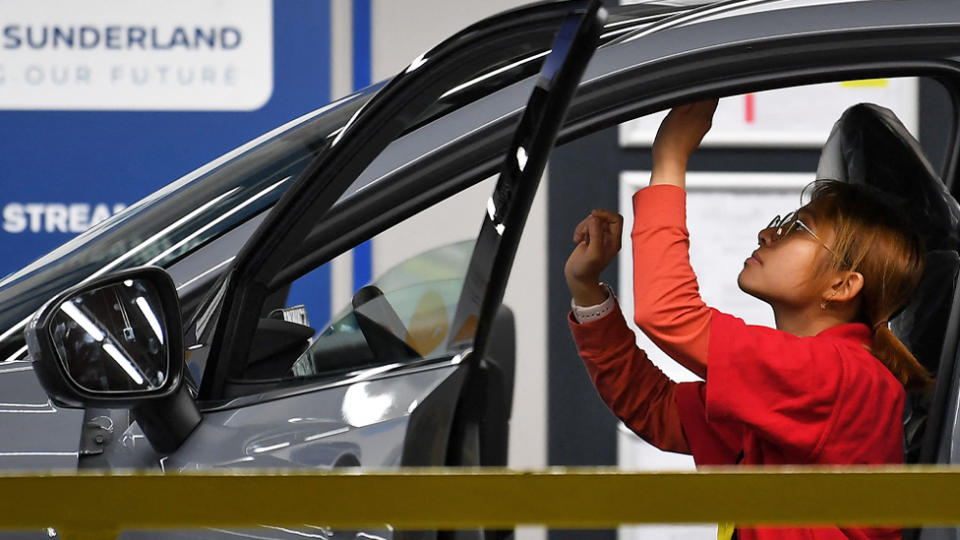 A female worker checks a car on the production line at the Nissan factory in Sunderland