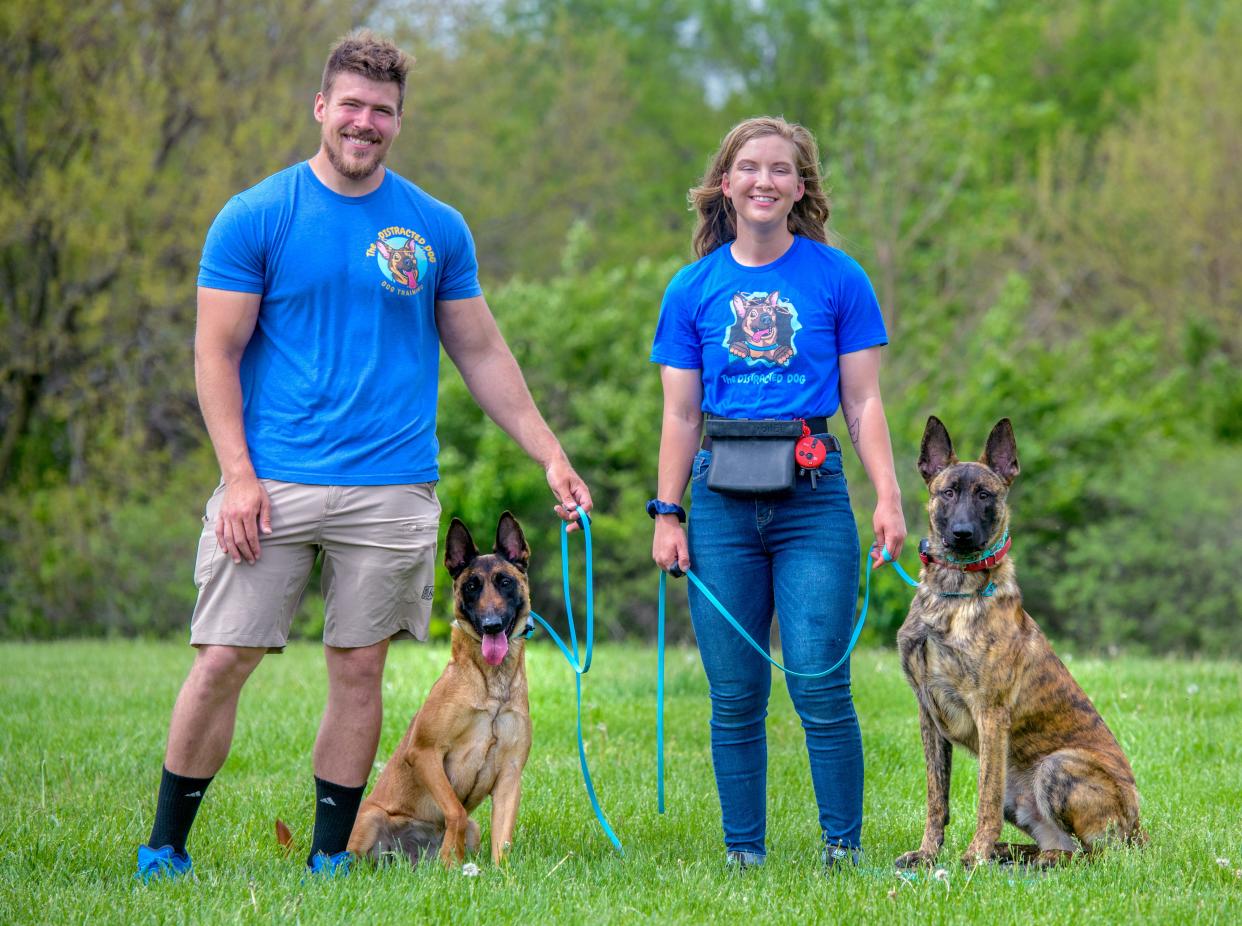 Patrick Sisco and Anna Sauder, owners of The Distracted Dog, a private dog training business, stand with two of their dogs, Oops, left, a 4-year-old Belgian Malinois, and Ghost, a 10-month-old Dutch Shepherd, during a training session at Alpha Park in Bartonville.