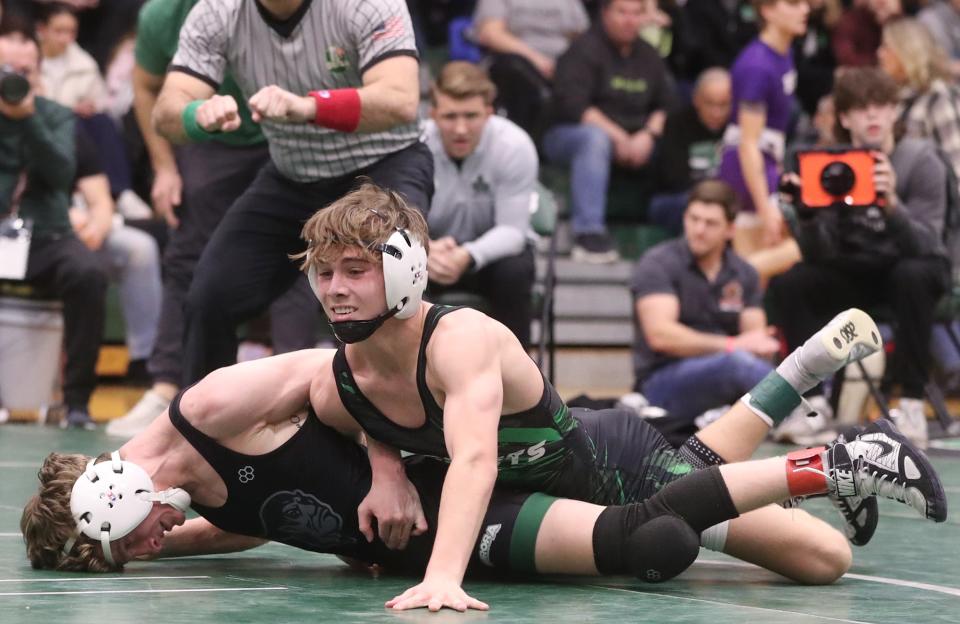 Highland's Austin Bickerton grapples with Aurora's Johnny Green in the championship match in 113 lbs. weight class at the 2024 Suburban League tournament at Highland High School in Medina on Saturday, Jan. 27, 2024. Highland's Austin Bickerton won the match to take the championship.