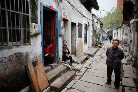 Local residents are seen in an old street in Dingshu town, where local shop owners make and sell handmade red clay tea-ware that is being done up as part of the local government push to attract tourists and promote the local pottery industry, in Yixing city, Zhejiang province, China November 14, 2017. REUTERS/Christian Shepherd