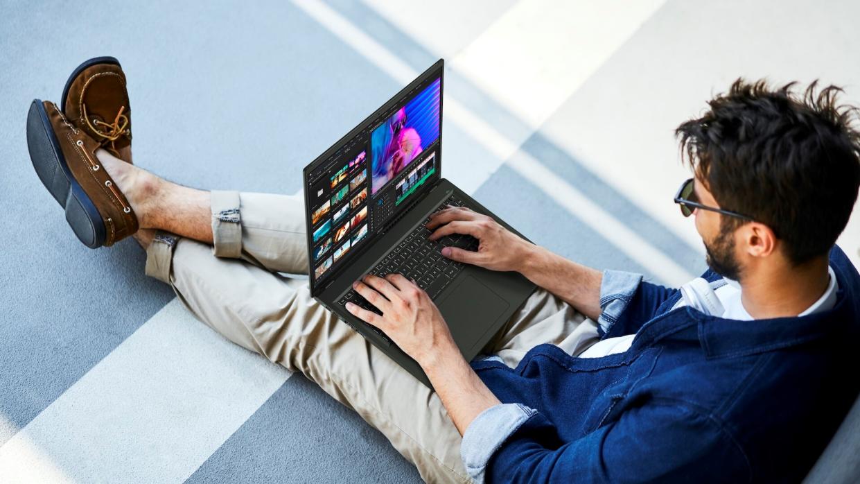  A man sitting with the Acer Swift Edge 16 on his lap. 