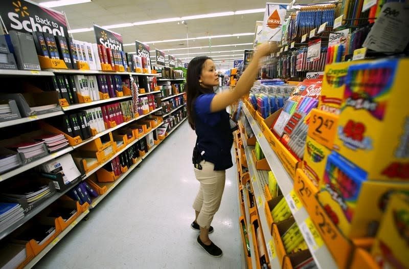 Walmart department manager Karren Gomes helps stock shelves with school supplies as the retail store prepare for back to school shoppers in San Diego, California August 6, 2015.  REUTERS/Mike Blake 