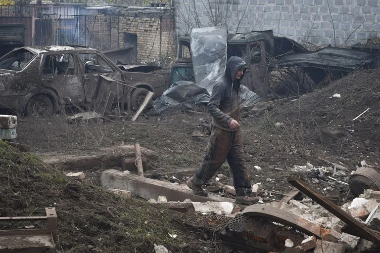 A local resident walks in yard of small business that was damaged after an overnight Russian attack in Kramatorsk, Ukraine, Thursday, Oct. 27, 2022. (AP Photo/Andriy Andriyenko)