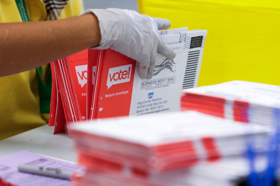 An election worker opens envelopes containing vote-by-mail ballots for the August 4 Washington state primary at King County Elections in Renton, Washington on August 3, 2020. (Jason Redmond/AFP via Getty Images)