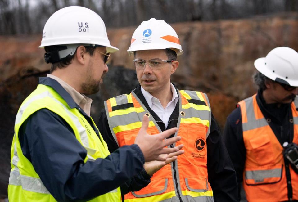 U.S. Secretary of Transportation Pete Buttigieg (C) visits with Department of Transportation Investigators at the site of the derailment on February 23 2023 in East Palestine, Ohio.